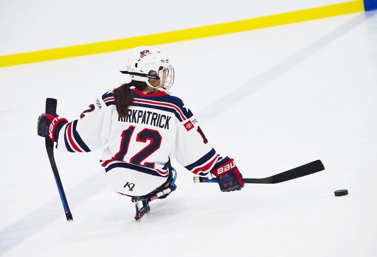 a woman in a hockey uniform is playing sled hockey