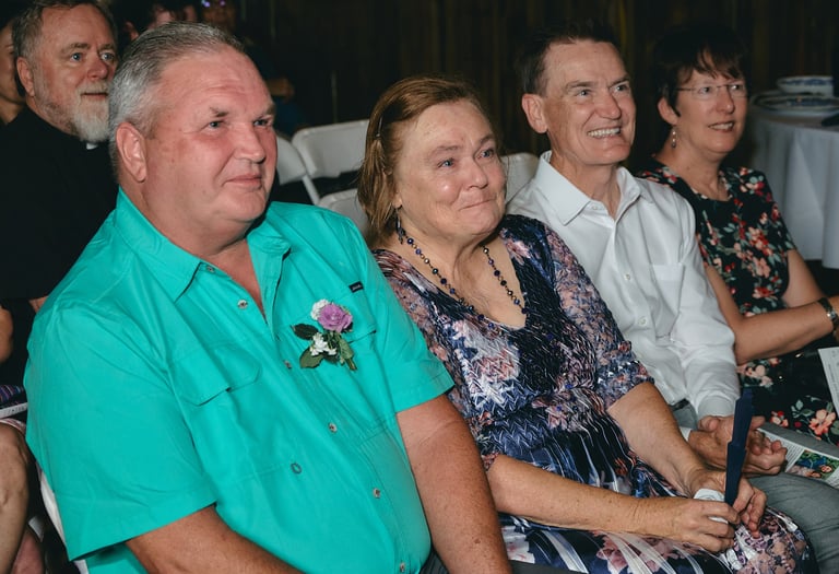 a group of people sitting in chairs at a wedding and a woman crying