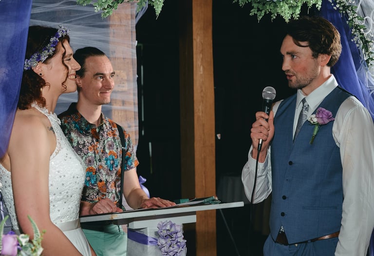 a groom holding a microphone giving a speech to the bride