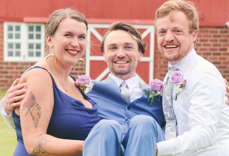 a man and woman carrying a groom for a picture in front of a barn