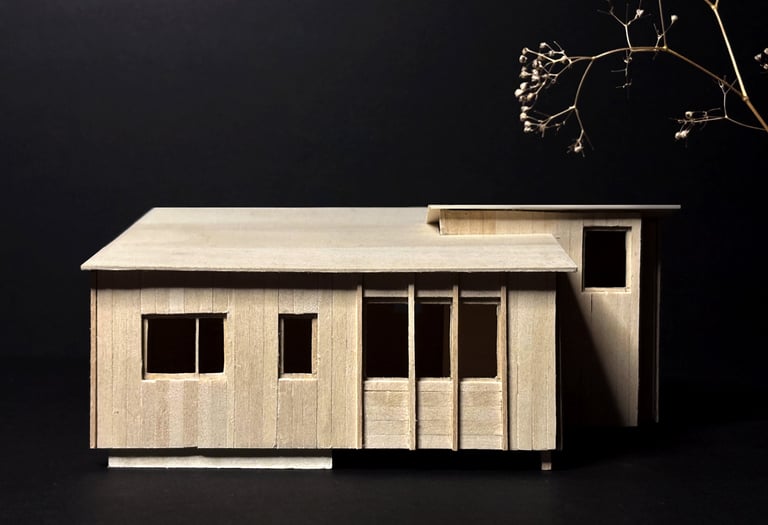 Handcrafted basswood architectural model of a modern cabin design against a dark background.