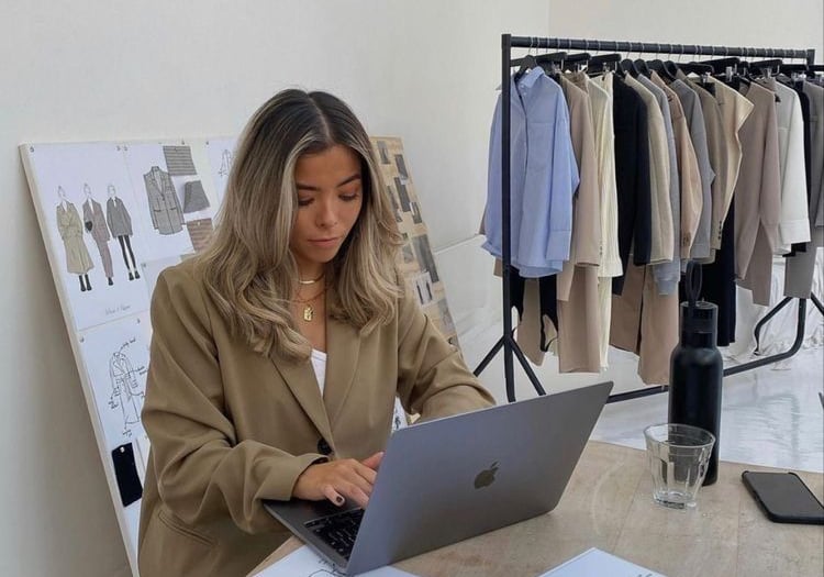 a woman sitting at a table with a laptop computer