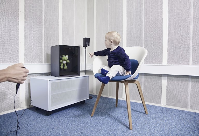 Criança fazendo exame de audiometria com reforço visual