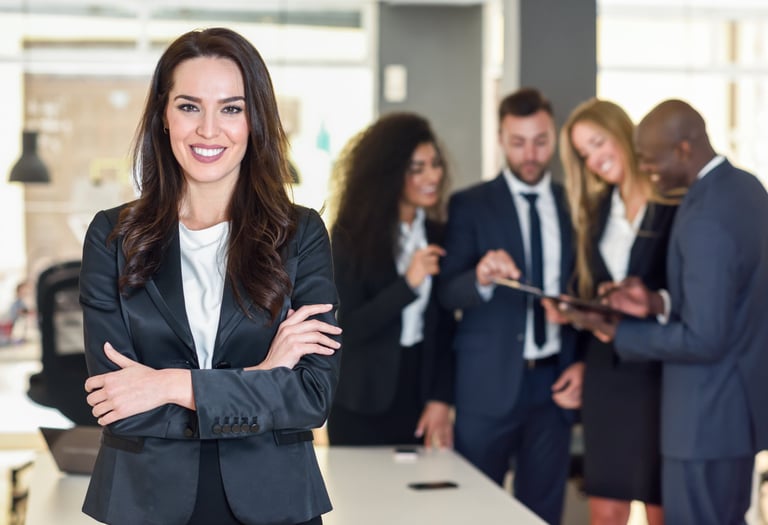 mujer en un traje parada al frente de un grupo de trabajo