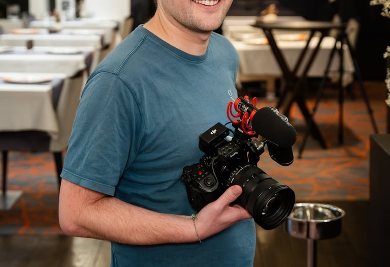 a man holding a camera and smiling