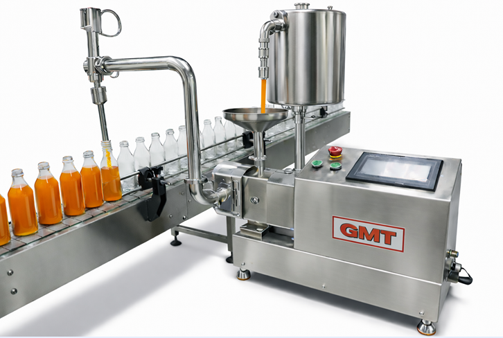 Automatic stainless steel liquid filling machine bottling orange juice into glass bottles on a conveyor belt.