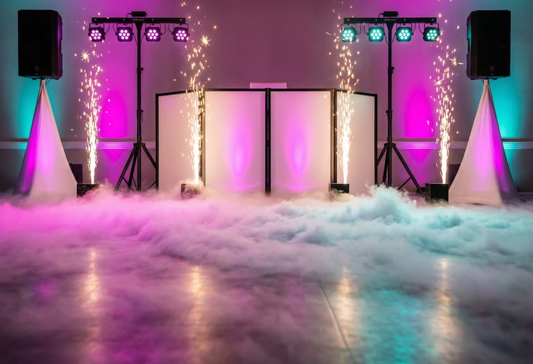 Professional wedding DJ setup with low fog machine effects, cold sparklers, and colorful stage lighting