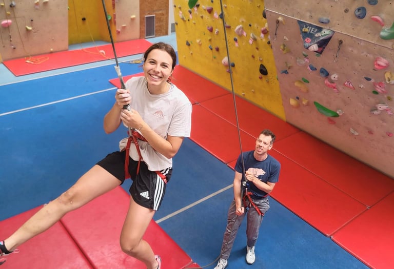 Kletterkursteilnehmer sichert seine Partnerin im Toprope Kletterkurs in Wien