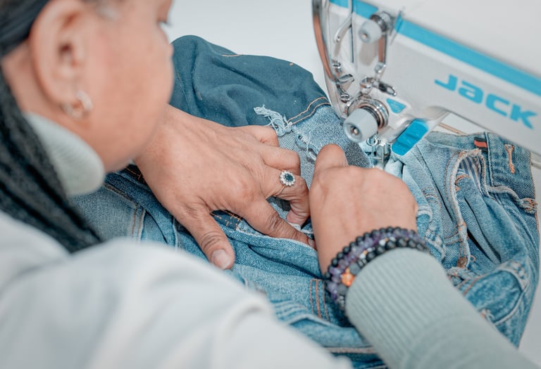 Modista arreglando un pantalon jeans en el taller de la costura