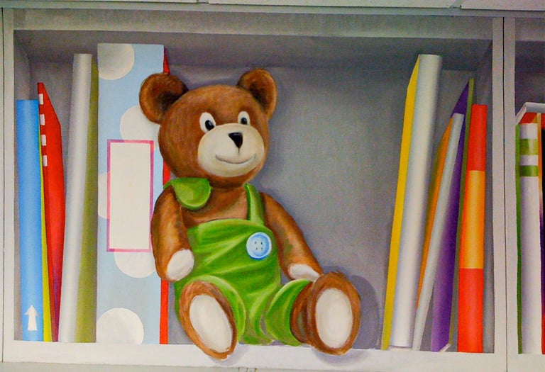 Trompe l’oeil bookshelf mural with stuffed bear and colorful books by House of Lyria