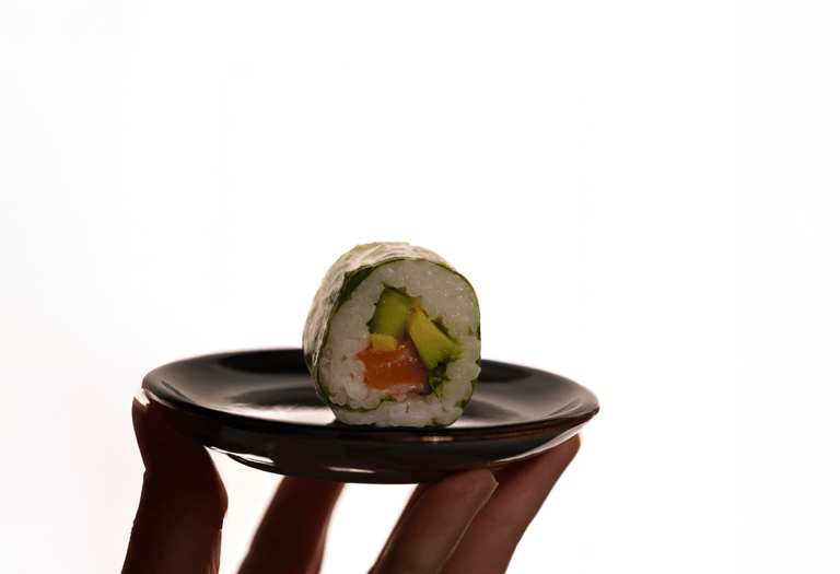 un sushi posé sur une assiette avec un fond blanc très lumineux