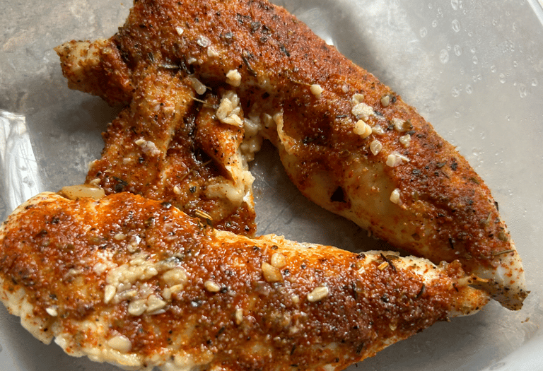 Baked Chicken Broil sample image cooked with glazed spices ontop and garlic slices.