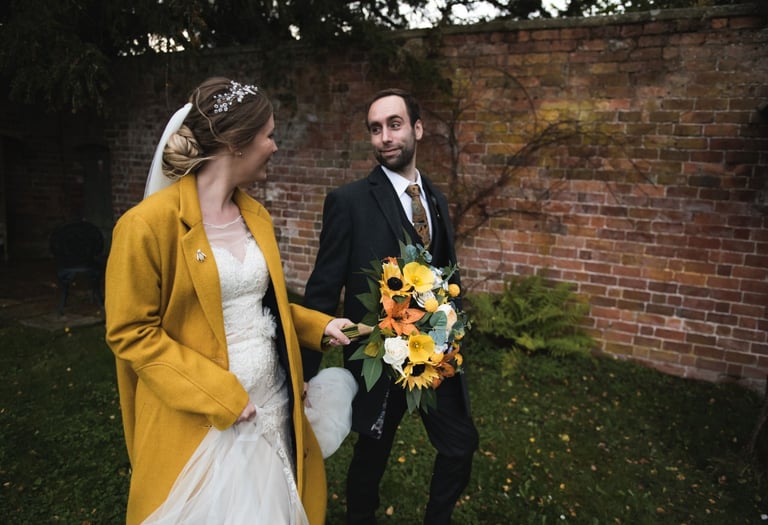 a bride and groom walking together holding hands