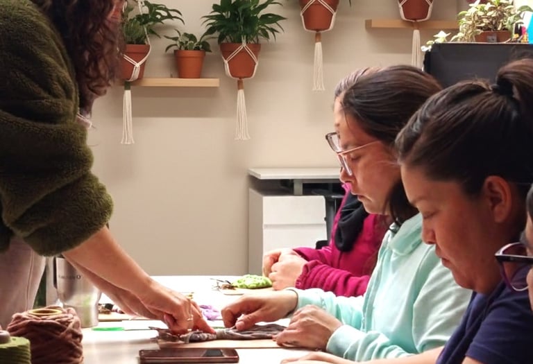 personas aprendiendo macramé y cordones de colores