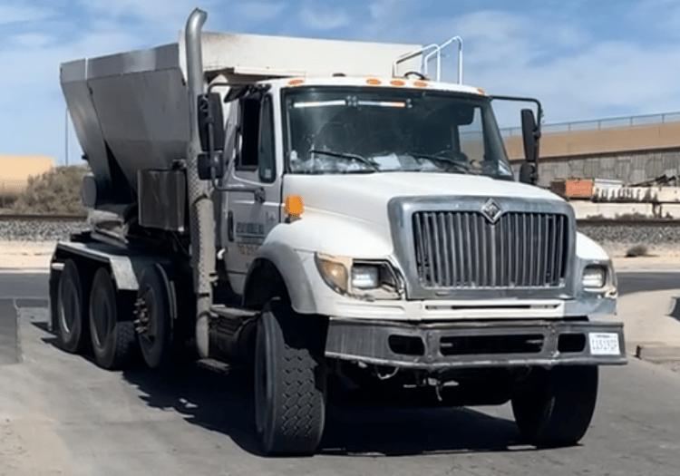 a dump truck with a cement mixer in the back ground