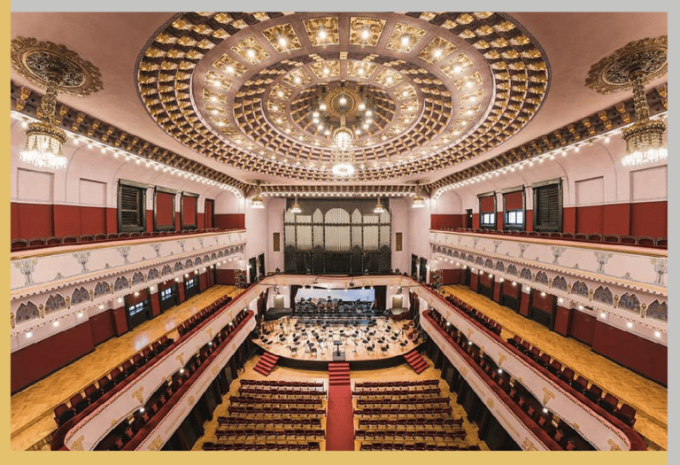 a concert hall with a large auditorium and a stage with a concert performance