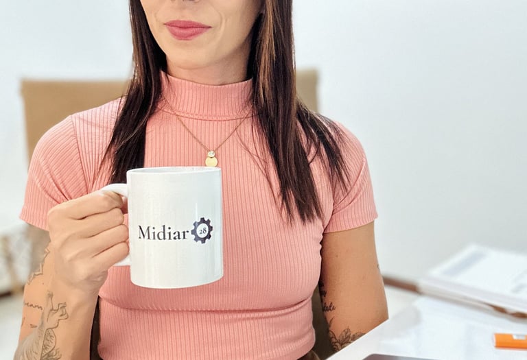 paula-sentada-a-mesa-olhando-para-camera-segurando-uma-caneca