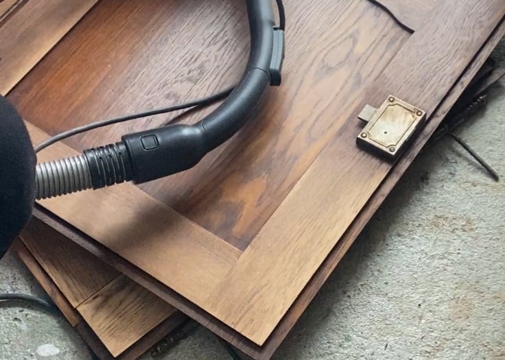 Cendrine l'artisane ponce une porte de meuble ancien pour le rénover dans l'atelier Chêne & Chiné