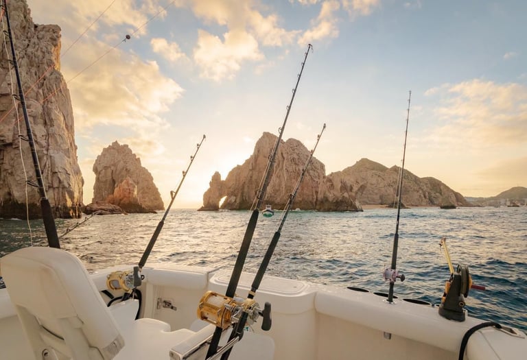 Deep sea fishing boat at sunset near El Arco rock formations in Cabo San Lucas.