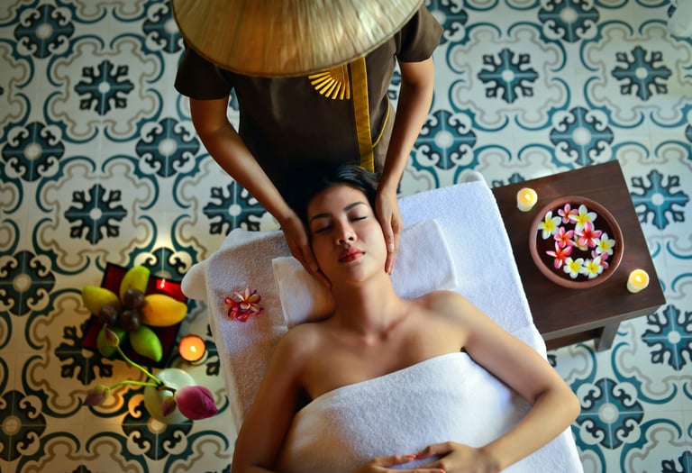 A woman receives a relaxing head massage at a luxury spa with traditional patterned tiles and flowers.