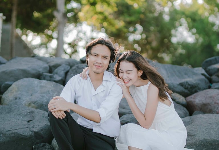Intimate couple sitting on rocks during sunset session at Novotel Tanjung Benoa Bali.