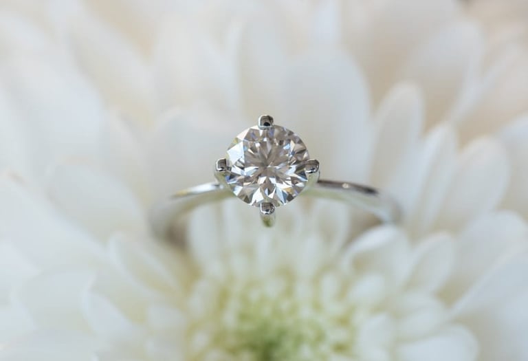 a Lab-Grown Diamonds CVD cut diamond ring with a diamond ring on top of a white flower