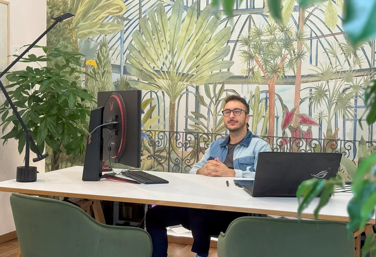 the owner sitting at the desk of the studio with his computer
