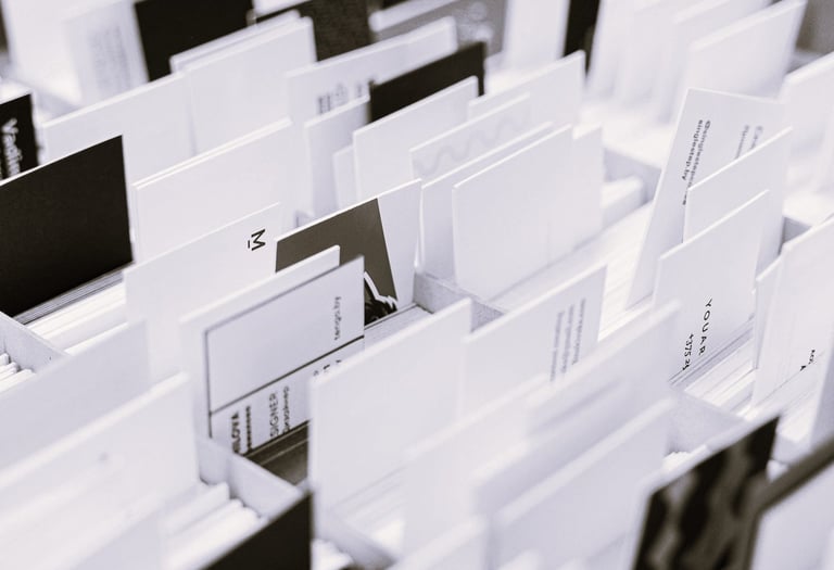 Photo en noir et blanc de plusieurs cartes de visite et supports triés