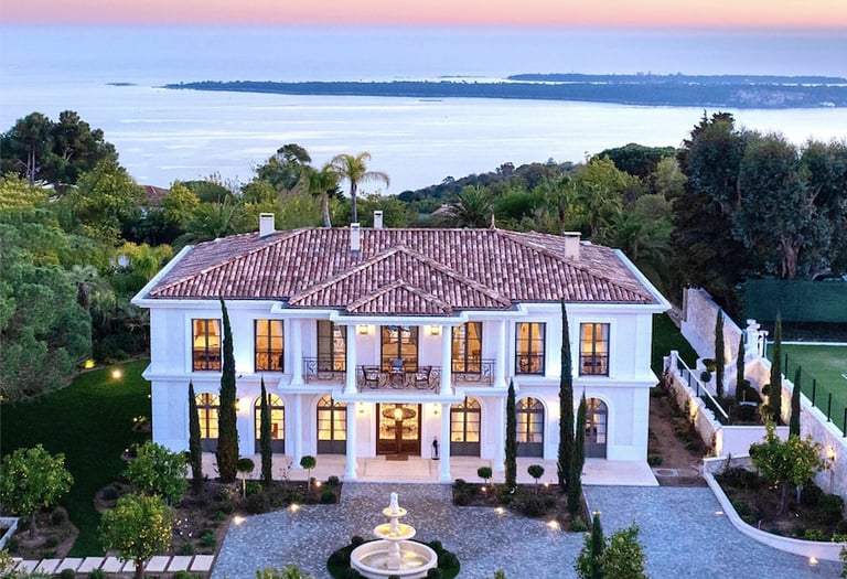 a large mansion with a fountain in the foreground