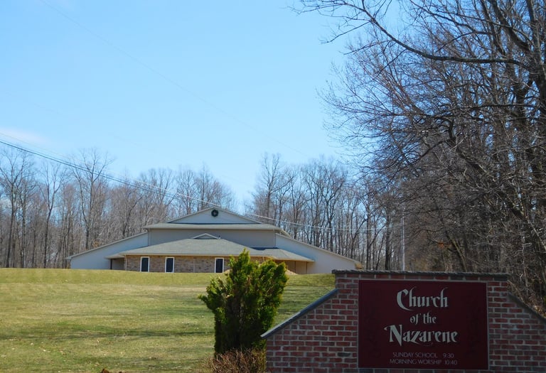 a church sign with a church in the background