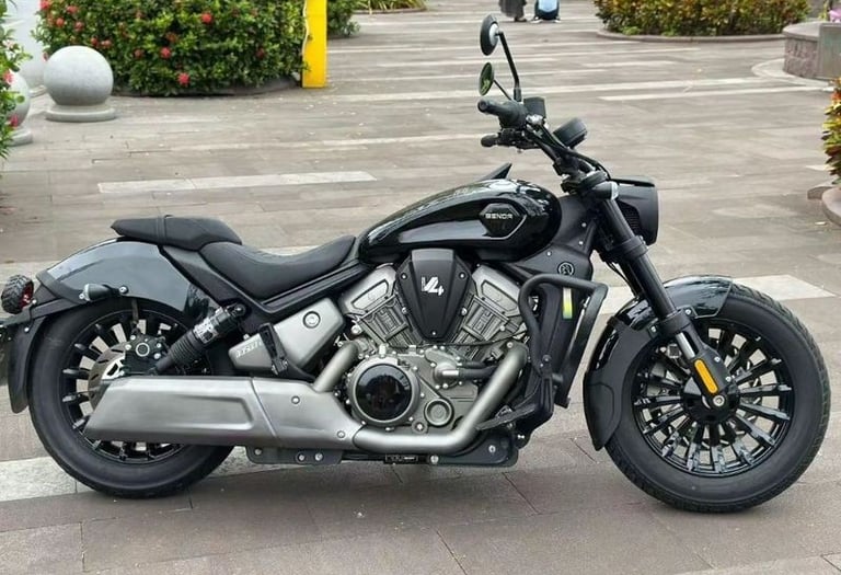 Side view of a black Benda Dark Flag 500 V4 cruiser motorcycle parked on a paved plaza.