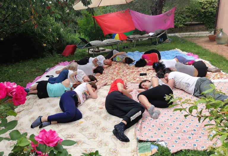 a group of people sitting on a blanket on a blanket, rilassamento, classe bioenergetica
