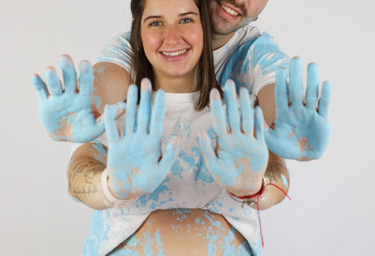 Sessió de fotos de gender reveal a Girona d'una parella amb pintura blava en estudi fotogràfic