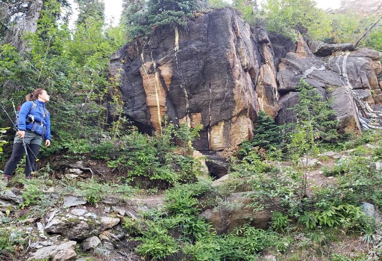 andree hiking looking up at a big rock