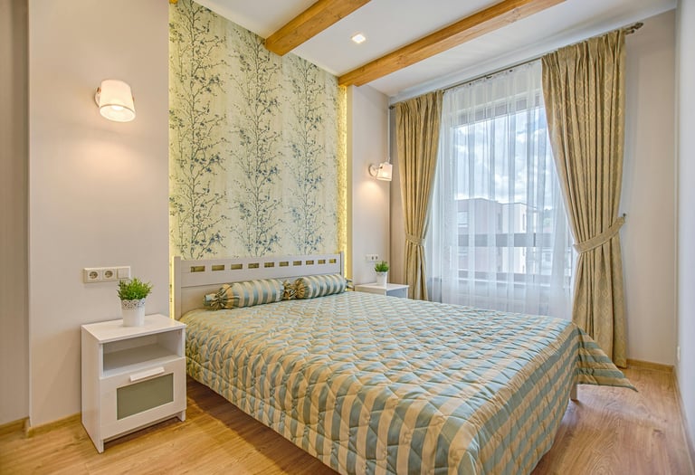 Modänes Hotelzimmer mit schickem Interieur einem Bett, Beistelltisch und hellen Vorhängen