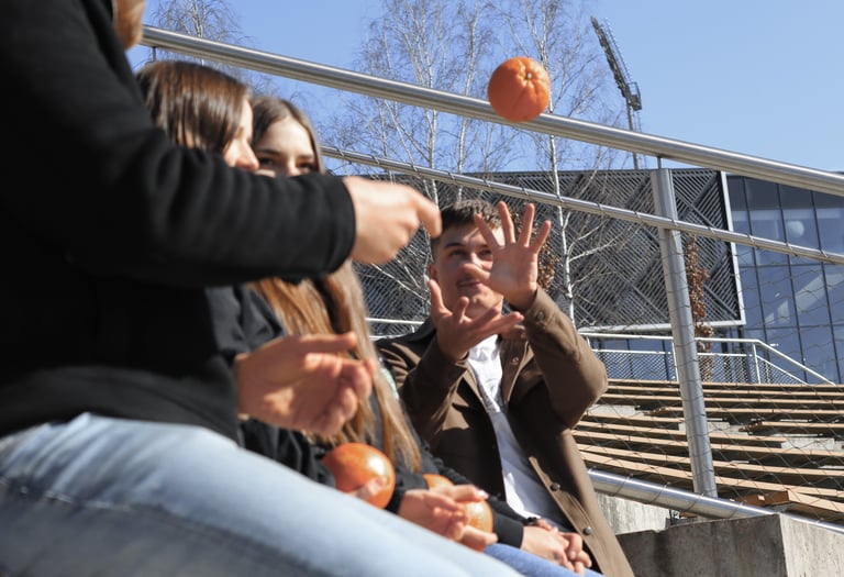 Vaikinas meta apelsina kitam