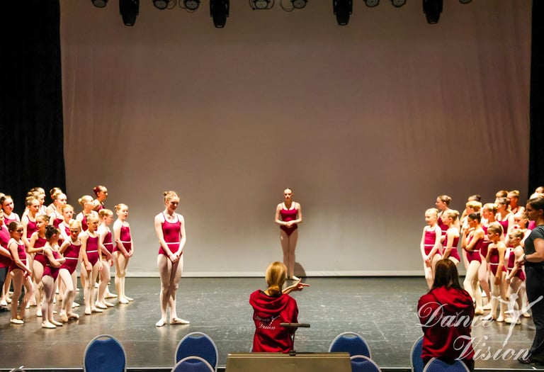 a group of young girls in red and white outfits on stage