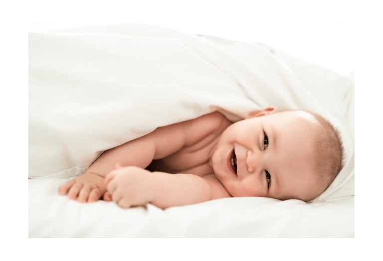 a baby is smiling and laying down on a bed