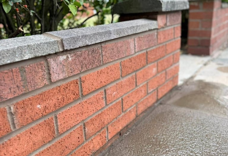 A red brick garden wall with a grey stone coping finish in Southport