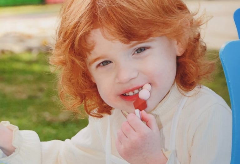 a young girl with red hair and a white shirt