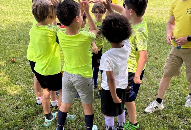 a group of children playing soccer in a field