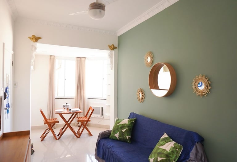 a couch with pillows and a table with chairs