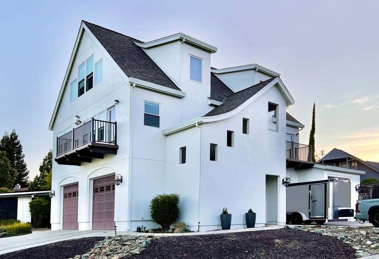 Corner perspective of a beautiful white French Revival architecture home.