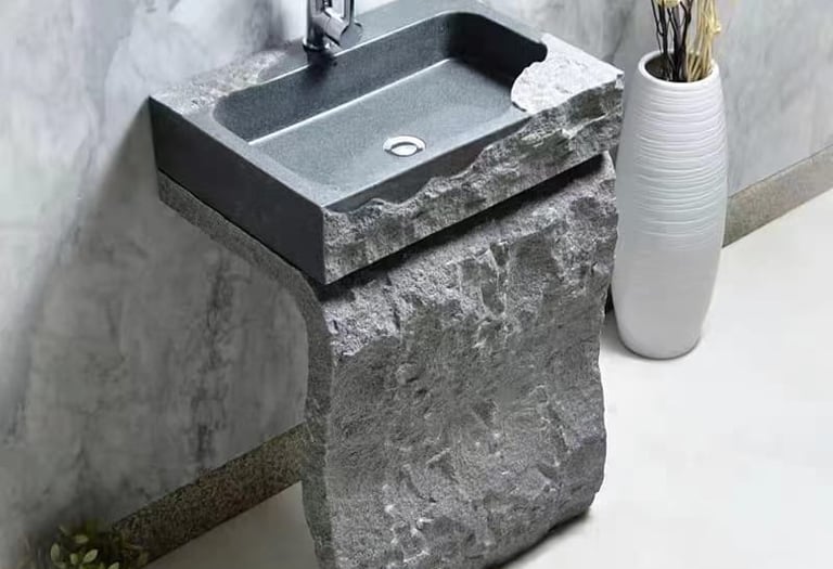 a stone sink with a stone sink and a vase with flowers