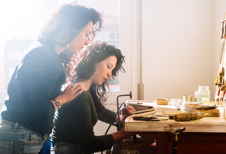 Dos mujeres haciendo una pieza de macramé en un taller.