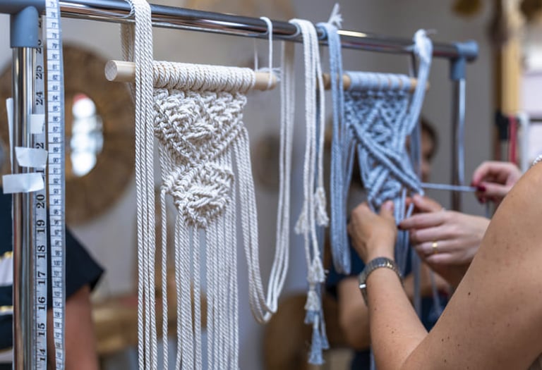 Grupo de personas creando piezas de macramé con hilos de algodón blanco y azul.
