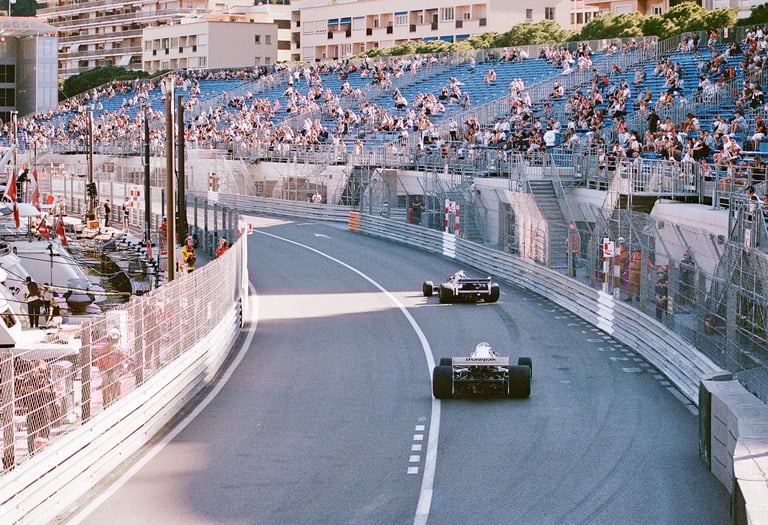 a race car racing down a track with spectators watching