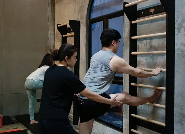 Instructer guide member about body setup and performance on wall bar