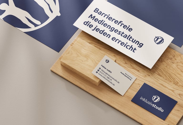 Zwei Visitenkarten, ein Flyer und Briefpapier auf Holzplatte