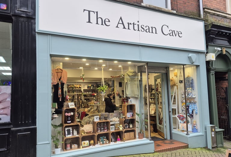 The Artisan Cave storefront featuring handmade gifts and local crafts in a boutique window display.